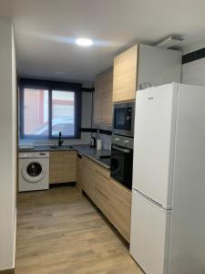 a kitchen with a white refrigerator and a window at Apartamento El Atardecer in El Perelló +5 photos