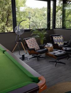 a living room with a couch and chairs and windows at Umoya Safari Lodge in Matlhagame