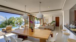 a dining room and living room with a table and chairs at Malimbu Cliff Villa by Elite Havens in Senggigi