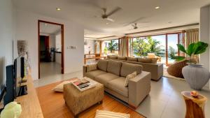 a living room with a couch and a tv at Malimbu Cliff Villa by Elite Havens in Senggigi