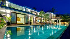 a swimming pool in front of a house at night at Malimbu Cliff Villa by Elite Havens in Senggigi