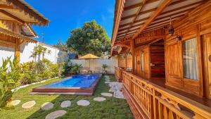 a backyard with a pool and a house at Dunya Villa in Gili Air