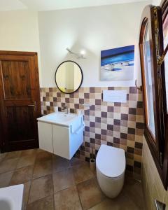 a bathroom with a toilet and a sink and a mirror at Dimora degli ulivi in Badesi +27 photos