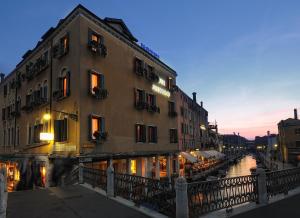 a building next to a river in a city at Hotel Arlecchino in Venice