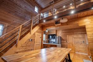 a large wooden room with a wooden table and stairs at M-Style MOTOSUKA in Katakai