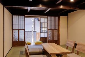 伊势市Nipponia Hotel 伊勢河崎 商人町的一间有桌子、椅子和窗户的房间 更多37张照片