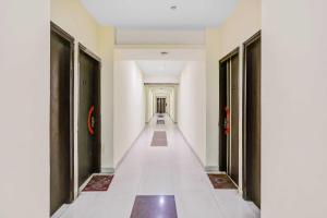 a corridor of a building with black doors and white floors at Collection O Patparganj Max Speciality Hospital in New Delhi