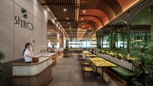 a woman standing at a counter in a restaurant at ARTOTEL Living World Kota Wisata 