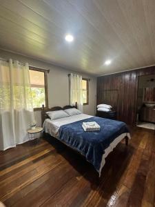 a bedroom with a large bed with a blue blanket at Rancho and Modern Rustic House with a Valley View in Venecia