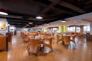 a dining room with wooden tables and chairs at Sun City Hotel Haikou in Haikou