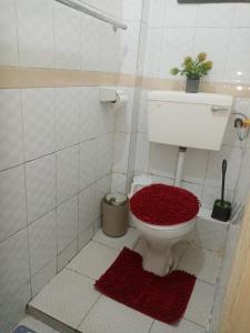 um banheiro com um vaso sanitário com tapetes vermelhos no chão em Mo Homes - Studio in South B, 15mins from JKIA, Wilson Airport & Nairobi CBD em Nairobi