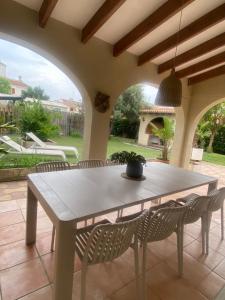 a table and chairs on a patio with a table and a potted plant at La casa de bega de mar in Sueca