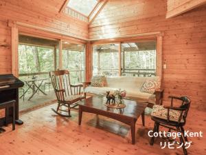 a living room with a couch and a table at Lodge Kent & Cottage Kent in Hokuto +17 photos