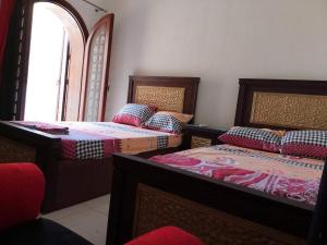 una camera da letto con due letti e una finestra di Four bed rooms chalet in marina 7 a El Alamein
