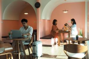 a group of people sitting at tables in a restaurant at TK Mansion in Ban Kohong