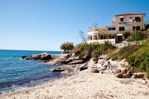 ein Gebäude am Strand neben dem Wasser in der Unterkunft Hotel La Stella in Seccheto