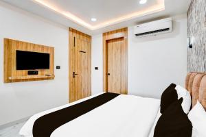 AyodhyaCollection O Ram Mandir Ayodhya Formerly Hotel Aarambh的一间卧室，墙上有一张床和一台电视