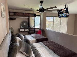 a bedroom with two beds and a ceiling fan at Loft Sole Mio in Orizaba