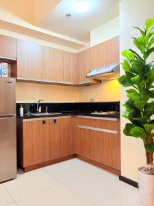 a kitchen with wooden cabinets and a stainless steel refrigerator at Galini Suites in Manila