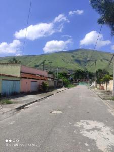 an empty street with a mountain in the background at Cantinho Do Sossego in Nova Iguaçu