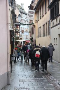 un grupo de personas caminando por una calle en Les Dentelles - Appartement meublé design Petite France, en Estrasburgo