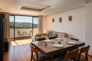 a living room with a table with chairs and a couch at Lobos Horizon by An Island Apart in Câmara de Lobos +12 photos