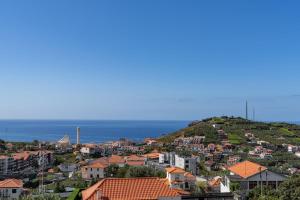 a town on a hill with the ocean in the background at Lobos Horizon by An Island Apart in Câmara de Lobos