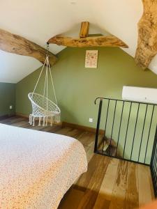 Un dormitorio con una cama y un columpio. en La Chance Spa cottage 6 personnes, en Orges