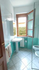 une salle de bain avec un lavabo et des toilettes et une fenêtre dans l'établissement Casa Irene Marina di Massa, à Marina di Massa