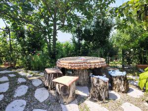 a table and four stools sitting on tree stump logs at NarInn Guesthouse in İsmayıllı