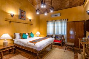 a bedroom with a large bed and a chair in it at Unnati Cultural Village in Maruwā Ghāt