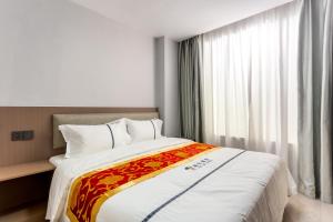 Postel nebo postele na pokoji v ubytování 万象海尔国际大酒店 瓦岱机场店提前预约免费接送机