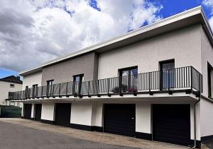 a white building with a balcony on top of it at Neues Ruhrtal Apartment 5 mit Klimaanlage in Wickede (Ruhr)