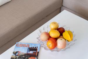 a bowl of fruit on a table next to a magazine at Ocean View Playa del Aguila in Playa del Aguila