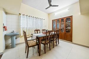 - une salle à manger avec une table, des chaises et un lavabo dans l'établissement Vintage Haven Leafy Getaway Luxury Villa in Indiranagar by Spacez, à Bangalore