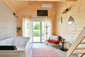 a bathroom with a tub and a tv on the wall at Le Filet Tendu in Marmoutier