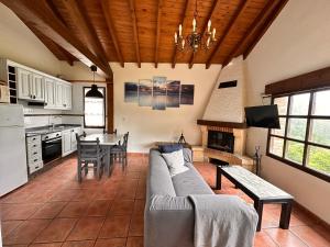 a kitchen and living room with a couch and a table at La Casita de La Nozal de la Peña in Villaviciosa