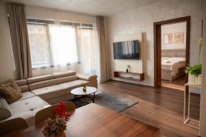 a living room with a white couch and a television at Villa Dunaj 2 in Dunajská Streda