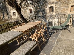 a wooden table and chairs next to a fence at Casa Sciresee in Palagnedra