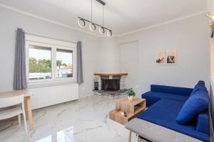 a living room with a blue couch and a fireplace at Adorable Modern Guesthouse 2 in Perea