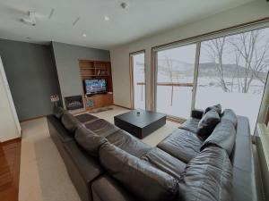 a living room with a large couch and a large window at Yutaka 2 in Kutchan