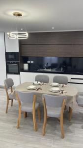 a dining room with a table and chairs in a kitchen at Alessio Beach House in Durrës