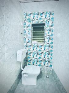 a bathroom with a toilet and a window at Saz ins banglow in Neral