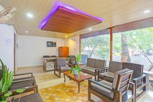 a living room with chairs and a table at FabHotel 22 Squares Living Spaces - Nr Calangute Beach in Calangute