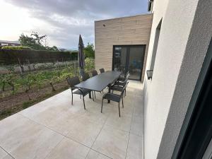 a dining table and chairs on a patio at COLMARandCo au coeur des vignes in Ingersheim