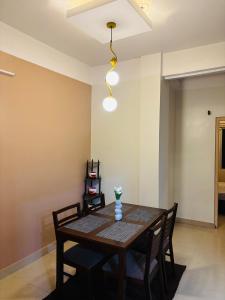 a dining room with a wooden table and chairs at Miss Tea Home in Agartala +7 photos