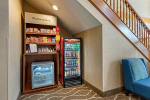 a refrigerator next to a staircase with a blue chair at Comfort Suites Salem in Salem