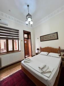 une chambre avec un lit avec des draps blancs et une fenêtre dans l'établissement Hotel POYI KALON terrace حلال, à Boukhara