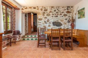 a dining room with a table and a stone wall at Masía Can Garriga, Casa Gran in Girona +21 photos