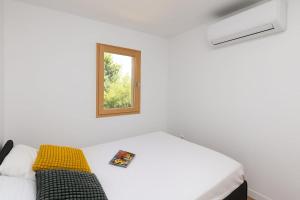 a white room with a bed and a window at Holiday Home Olive&Sun in Mlini
